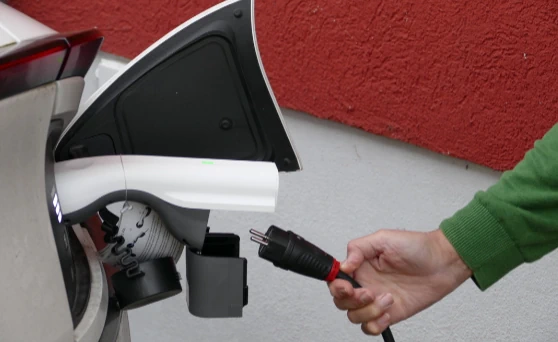 Nutzung eines Vehicle-to-Load (V2L) Adapters an einem Kia Elektroauto, in den ein Schuko-Stecker eingesteckt wird.